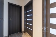 zprava doleva: vpravo dveře do obývacího pokoje s kuchyňským koutem, pak dveře do ložnice, dveře do koupelny a úplně vlevo dveře do komory