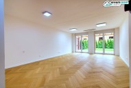 1a Prostorný obývací pokoj s novou dřevěnou podlahou a zahradou
